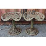 A pair of early 20th century cast iron stools previously tractor seats, 45cm wide x 49cm high (2).