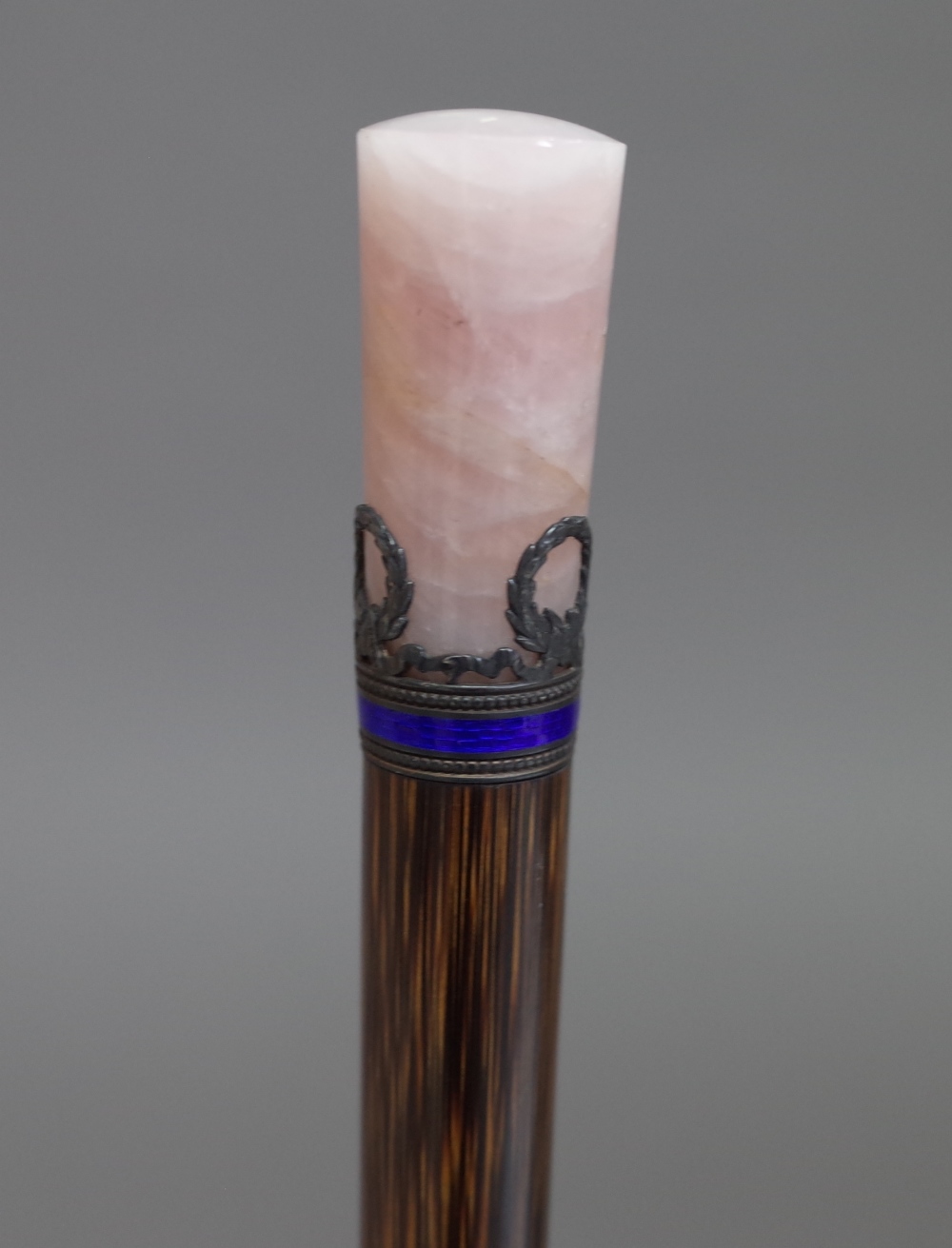 A silver and enamel mounted bamboo parasol handle with a rose quartz cylindrical handle, 30cm.