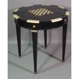 A 20th century ebonised circular games table on tapering square supports, 74cm wide x 78cm high.