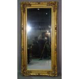 A 20th century gilt framed rectangular mirror with acanthus decoration, 180cm wide x 86cm high.