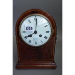 An Edwardian mahogany cased mantel clock of dome form with a white enamel dial and two train