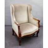 A 19th century French floral carved walnut framed square wingback armchair on scroll supports,