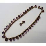 An amethyst necklace, formed as a row of graduated oval cut amethysts, on a cylindrical clasp,