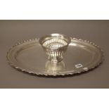 A silver coloured white metal serving dish, of shaped oval form, decorated with a scrolling border,