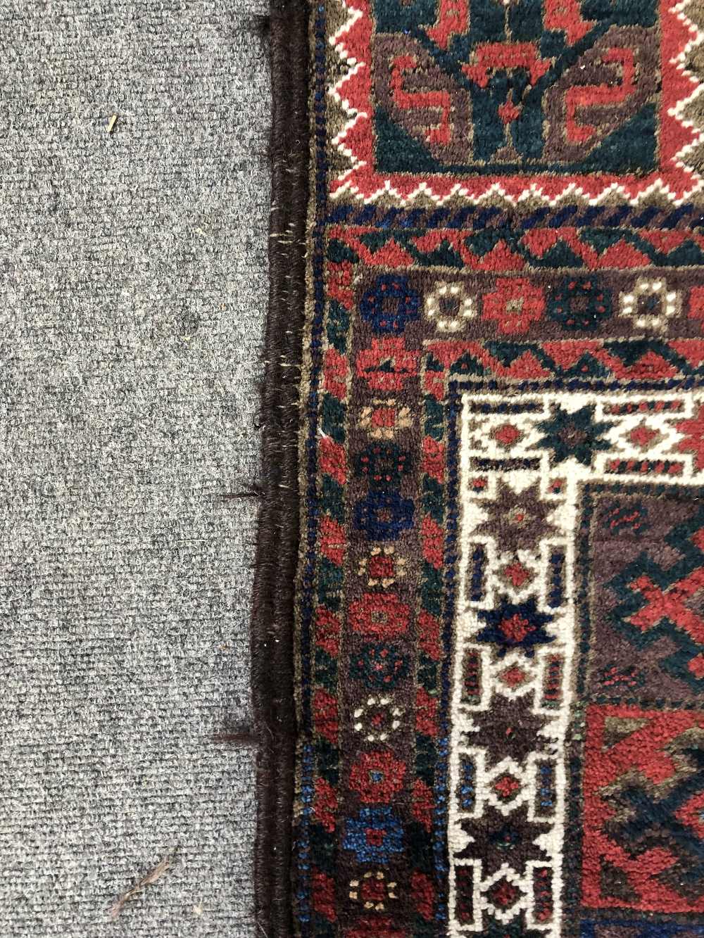 A Persian tribal rug with multicoloured repeating gul design within stepped white borders, - Image 7 of 7