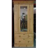 A 20th century pine wardrobe with mirrored door over two drawers on plinth base,