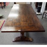 A 17th century style oak refectory table, on a pair of baluster columns united by stretcher,
