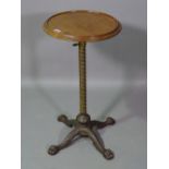 A Victorian mahogany topped wine table the spiral twisted brass column on cast iron claw feet,