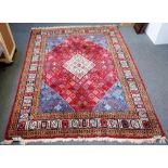 A Joshaghan carpet, Persian, the madder field with an ivory diamond, matching indigo spandrels,