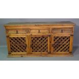 Tucan; a 20th century hardwood sideboard with three drawers over lattice panel doors,