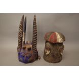 An African tribal helmet mask, polychrome painted carved wood with crested surmount,