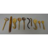 Treen wares; a collection of ethnic and other wooden spoons and a shaped stick, (31cm), (10).
