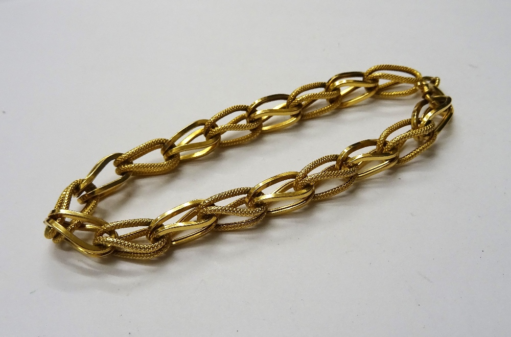 A gold bracelet, designed as a series of textured links, alternating with plain links, detailed 750,