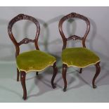 A set of six Victorian walnut framed balloon back dining chairs with serpentine seats,