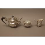A silver three piece teaset, comprising; a teapot, a sugar bowl and a milk jug,