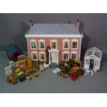 A 20th century Georgian style two storey dolls house with dolls, furniture,