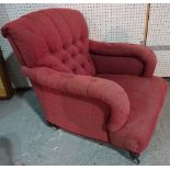 A mid-Victorian easy armchair with button back and overstuffed arms on turned supports,
