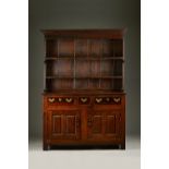 A mid-18th century oak dresser with enclosed two tier plate rack over three drawers and pair of