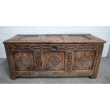 A 17th century oak coffer with triple panel lid and carved triple panel front,