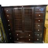 A 20th century hardwood side cabinet with a pair of cupboard doors over three long drawers flanked