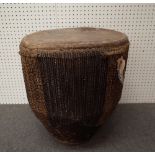 An African tribal drum or large proportions with leather hide and hair decoration to the circular