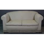 A 20th century mahogany framed two seat sofa, with rollover arms and white upholstery,
