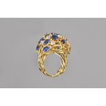 An 18ct gold, sapphire and diamond ring, pierced in an open work abstract foliate design,