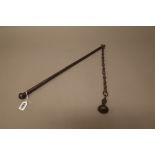 A Victorian steel mace, the bar handle with linked chain suspending an iron ball, 89cm overall.