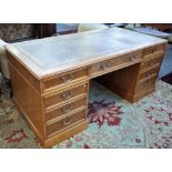 An 18th century style figured oak pedestal desk, with nine drawers about the knee,