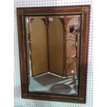 A 20th century red painted and gilt rectangular mirror, 65cm wide x 93cm high.
