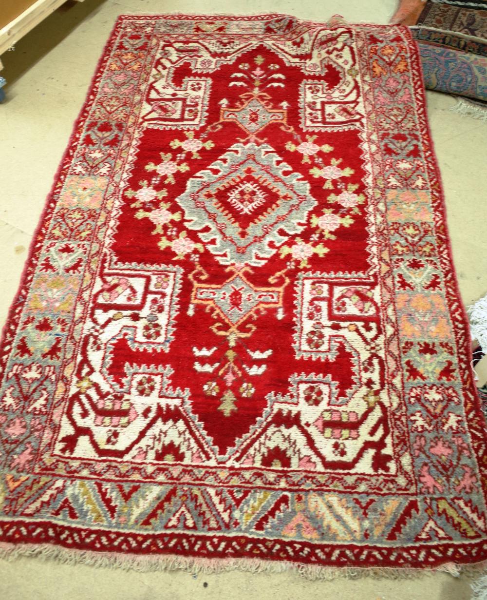 A red ground decorative rug possibly Turkish 210cm x 127cm.