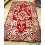 A red ground decorative rug possibly Turkish 210cm x 127cm.