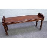 A mahogany window seat with pierced end stops on turned supports, 110cm wide x 51cm high.