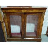 A Victorian marquetry inlaid figured walnut pier cabinet with a pair of glazed doors on plinth base,