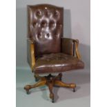 A 20th century mahogany framed button back brown leather office armchair.