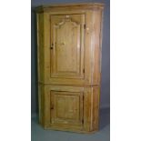 An early 20th century pine corner cupboard with panelled doors, 103cm x 186cm high.