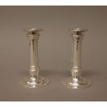 A pair of small table candlesticks, each of turned form, raised on a circular base, 12.