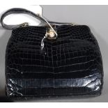 A black leather patent faux crocodile skin handbag, with single handle and gilt fittings,