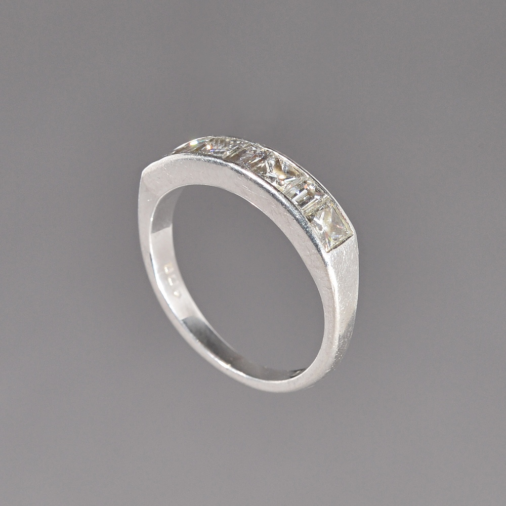A platinum and diamond seven stone half hoop ring, mounted with four princess cut diamonds,