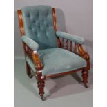 A Victorian mahogany framed low armchair with button back upholstery on ring turned supports.