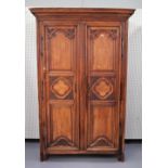 An 18th century French walnut armoire with pair of carved triple panel doors, on block feet,