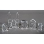 Swarovski; a group of four miniature glass houses and a miniature glass church, (5).