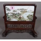 A 19th century Asian porcelain plaque in a hardwood stand, 24cm, (a.f.).