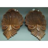 A pair of stained pine 'shell' carved wall brackets, 45cm high, (2).