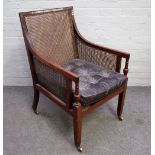 A George II mahogany framed library bergere with downswept arms on square supports,
