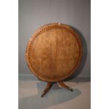 A Regency brass and ebony inlaid circular snap top centre table, on four downswept supports,