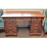A Victorian mahogany pedestal desk with three frieze drawers over a pair of carved cupboards,