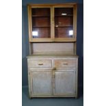 A 20th century pitch pine kitchen dresser with two door glazed top section over two drawers and