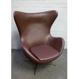 After Arne Jacobsen; an egg chair in brown leather on polished steel four point base,
