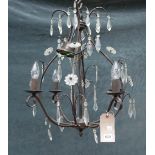 A modern patinated metal four branch chandelier of open frame form hung with cut glass drops,